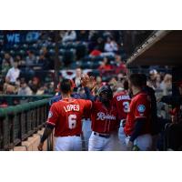 Shed Long gets high fives in the Tacoma Rainiers dugout