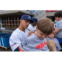 Mark Contreras of the Pensacola Blue Wahoos signs the shirt of a young fan