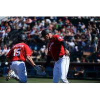 Jaycob Brugman of the Tacoma Rainiers gets a low five as he rounds the bases