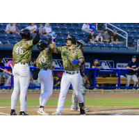 Biloxi Shuckers' Brock Wilken congratulated by Ernesto Martinez Jr. and Carlos D. Rodriguez