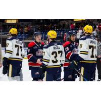 Saginaw Spirit's Graydon Jones and Zayne Parekh congratulae Erie Otters' Wesley Royston, Quinn McCall, and Lucas Ambrosio